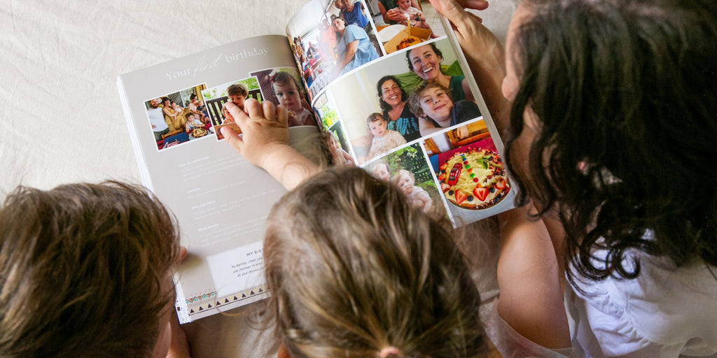 Family reading memory book on bed together