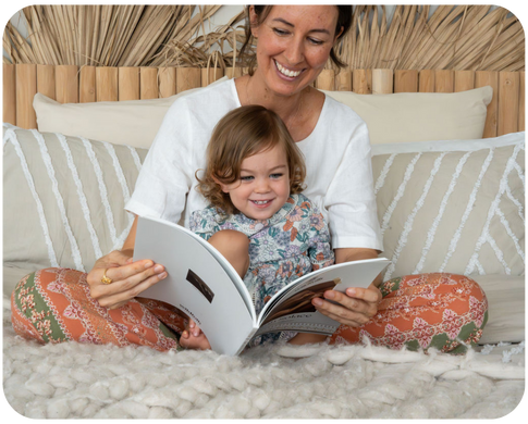 Mother and child reading memory book on bed